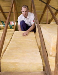 Photo of a man installing Bradford Gold Insulation in a roof