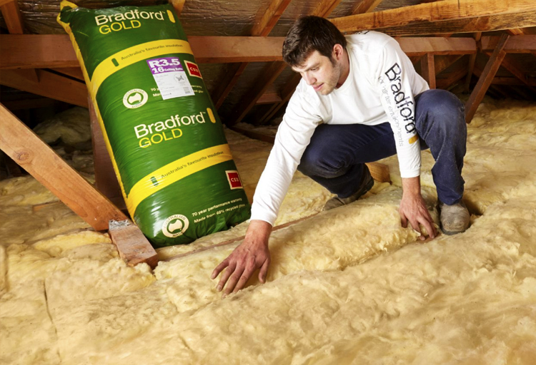 Photo of a man installing ceiling insulation in the roof