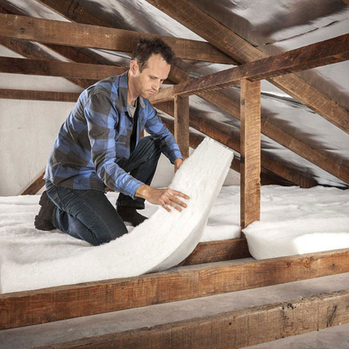 Photo of a man installing retrofit ceiling insulation batts